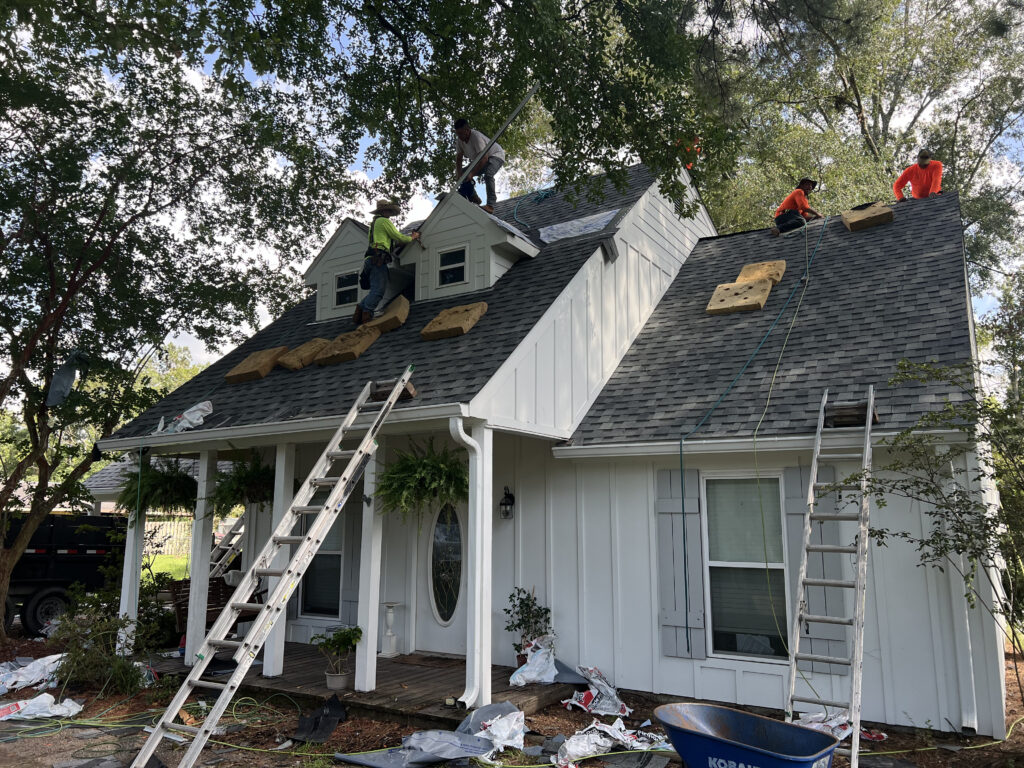 Roofing crew working on a white home