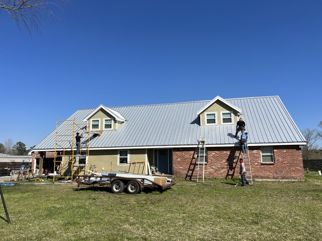 Metal roof installation on a brick home
